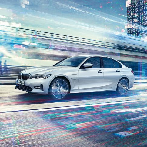 Kørende BMW 3-serie Sedan 330e set fra siden. Kørende BMW 3-serie Sedan 330e set fra siden i urbant miljø.