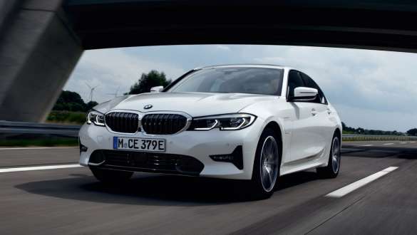 Plug-in-hybrid BMW 3-serie Sedan 2021 G20 set forfra let drejet kørende Plug-in-hybrid BMW 3-serie Sedan 2021 G20 set forfra let drejet kørende på en vej