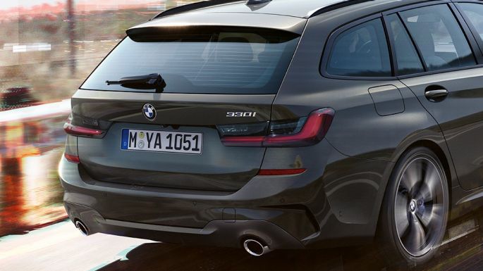 BMW 3-serie Touring set bagfra let drejet BMW 3-serie Touring set bagfra let drejet kørende på en bro foran landlige omgivelser