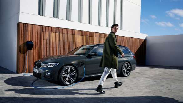 Plug-in-hybrid BMW 3er Touring 2021 G21 set fra siden let drejet under opladning Plug-in-hybrid BMW 3-serie Touring 2021 G21 set fra siden let drejet under opladning med model
