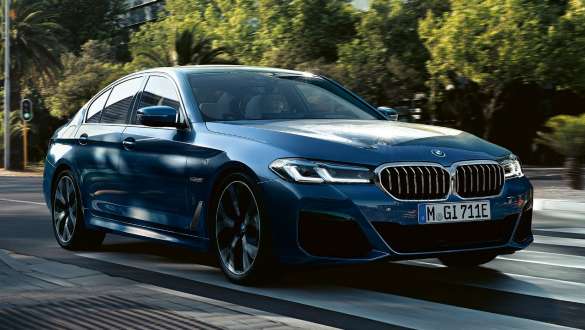 BMW 5-serie Sedan G30, set forfra let drejet BMW 5-serie Sedan G30 Facelift 2020 Phytonic Blue metallic, set forfra let drejet kørende på en vej
