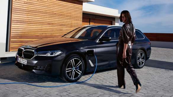 Plug-in-hybrid BMW 5-serie Touring 2021 G31 LCI set fra siden let drejet under opladning Plug-in-hybrid BMW 5-serie Touring 2021 G31 LCI set fra siden let drejet under opladning med model