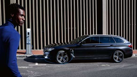Plug-in-hybrid BMW 5-serie Touring 2021 G31 LCI set fra siden under opladning Plug-in-hybrid BMW 5-serie Touring 2021 G31 LCI set fra siden under opladning med model