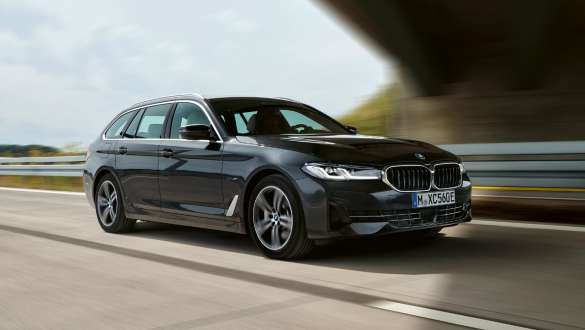 Plug-in-hybrid BMW 5-serie Touring 2021 G31 LCI set forfra let drejet kørende Plug-in-hybrid BMW 5-serie Touring 2021 G31 LCI set forfra let drejet kørende på en vej