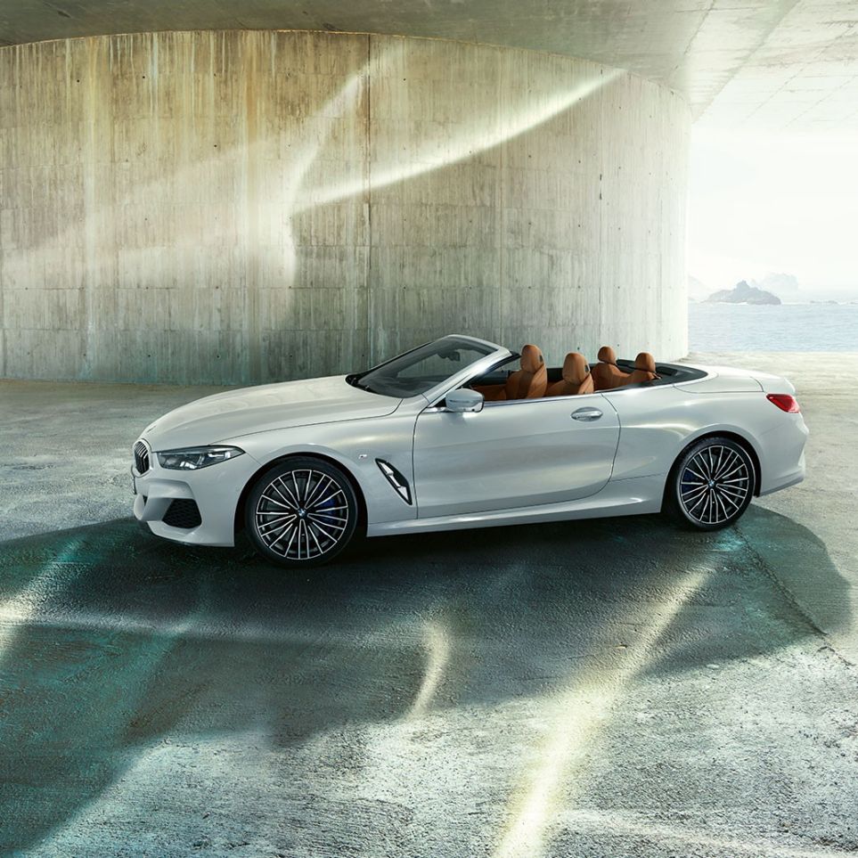 BMW M850i xDrive in Mineral White Metallic, set fra siden med åben stofkaleche. BMW M850i xDrive in Mineral White Metallic, set fra siden med åben stofkaleche.