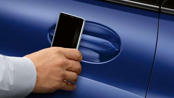 BMW Digital Key BMW 8-serie Coupé G15 LCI Facelift 2022 BMW Digital Key BMW 8-serie Coupé G15 M Portimao Blue metallic LCI Facelift 2022 hånd holder smartphone foran bildør