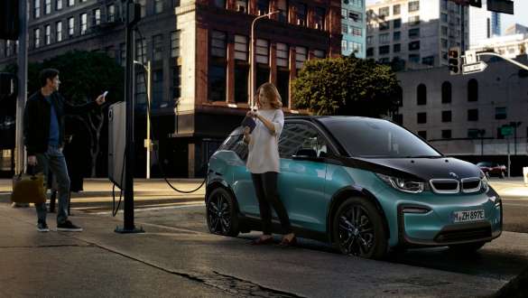 BMW i3 2018 ved en offentlig ladestation Jucaro Beige med detaljer i Frozen Grey metallic Et par oplader deres BMW i3 ved en offentlig ladestation I01 2018 Jucaro Beige med detaljer i Frozen Grey metallic