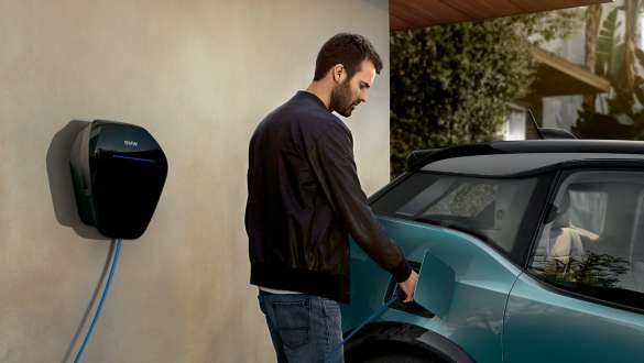 BMW i3 2018 ved en offentlig ladestation Jucaro Beige med detaljer i Frozen Grey metallic Et par oplader deres BMW i3 ved en offentlig ladestation I01 2018 Jucaro Beige med detaljer i Frozen Grey metallic