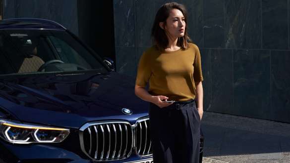 En kvinde foran en BMW BMW vejhjælp og nødhjælp En kvinde foran en BMW