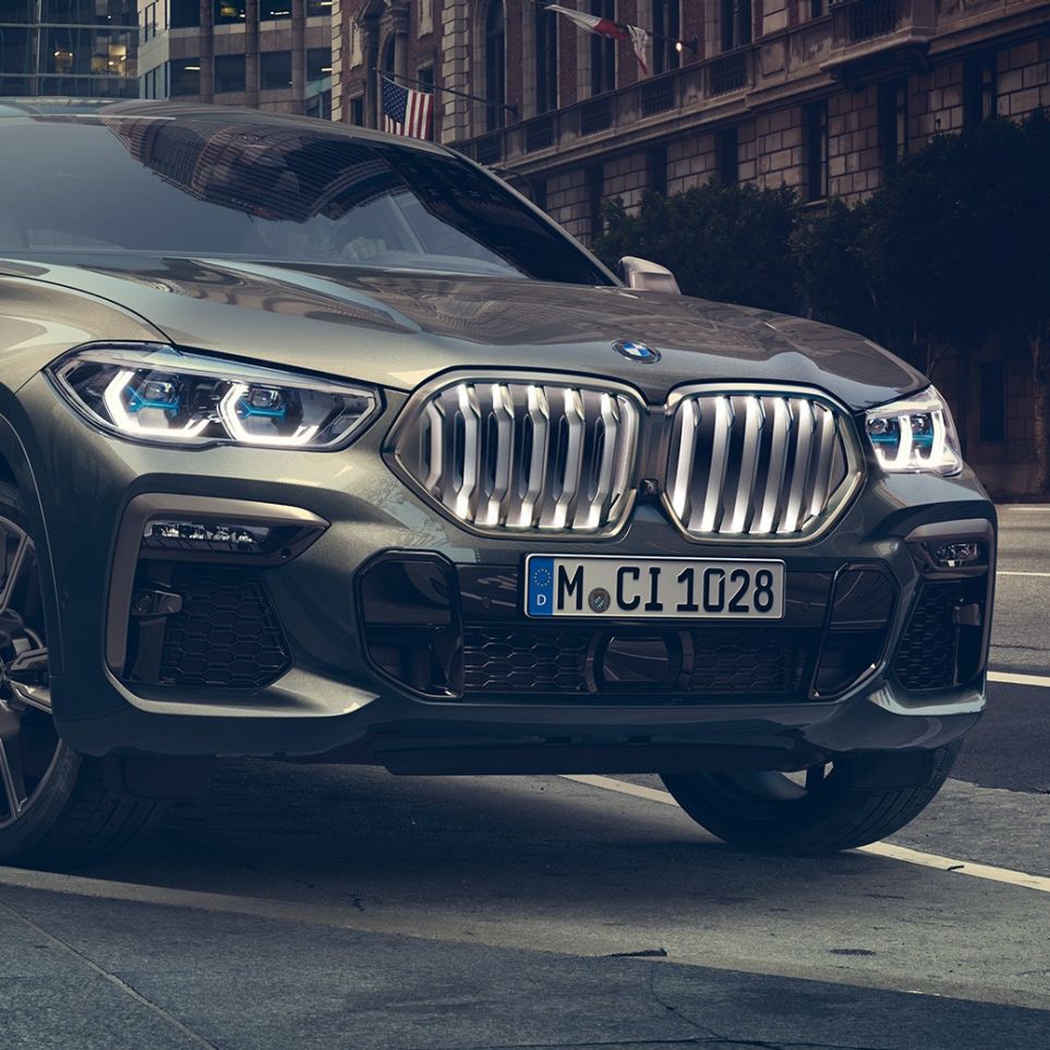 BMW X6 M50i stående BMW X6 M50i set forfra let drejet stående foran et urbant miljø