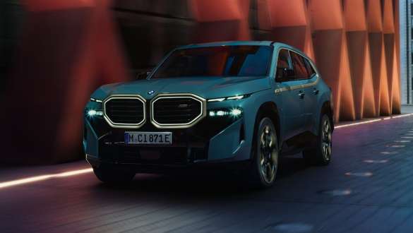 BMW XM G09 plug-in-hybrid set fra siden BMW XM G09 plug-in-hybrid set fra siden foran en bygning