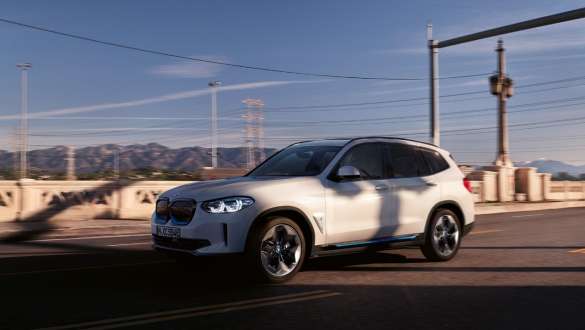 BMW IconicSounds Electric BMW iX3 G08 BMW IconicSounds Electric BMW iX3 G08 2020 Mineral White metallic kørende på en vej