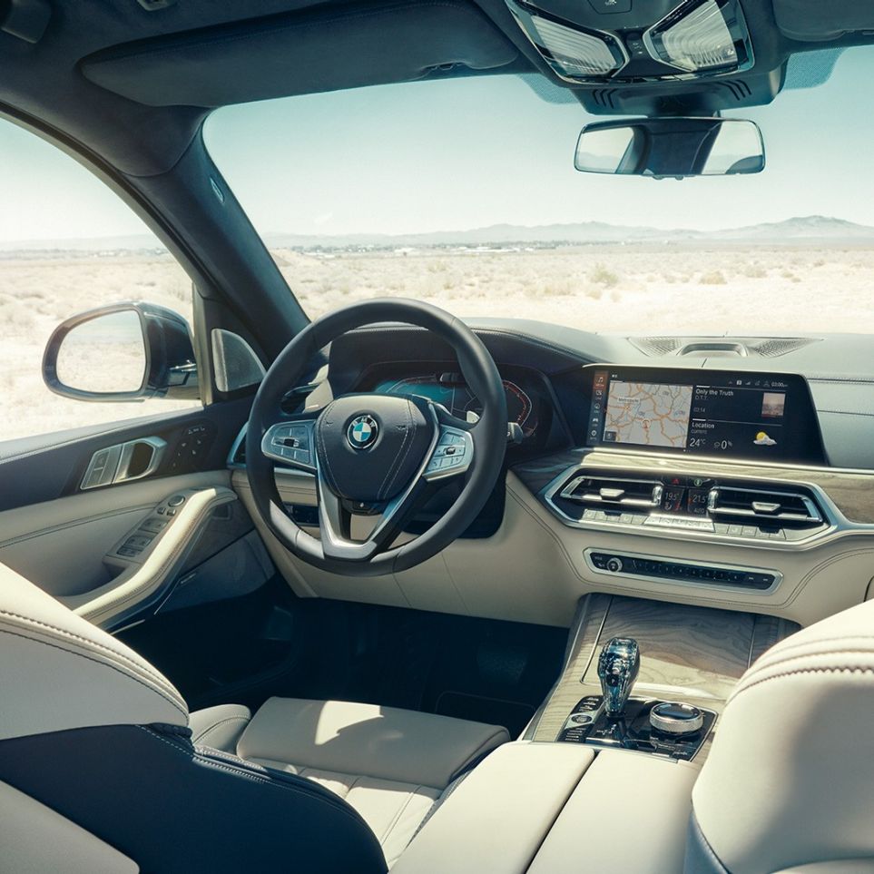 BMW Live Cockpit Professional BMW Live Cockpit Professional: set bagfra ind på første sæderække med fokus på rat og instrumentpanel