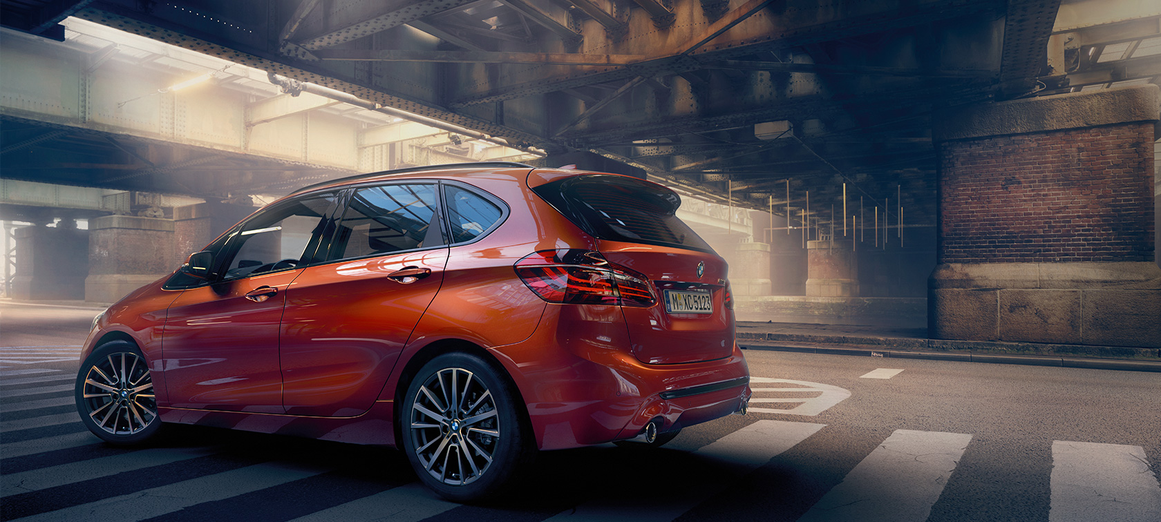 BMW 2-serie Active Tourer set fra siden BMW 2-serie Active Tourer F45 Facelift 2018 Sunset Orange Metallic set fra siden i en hal