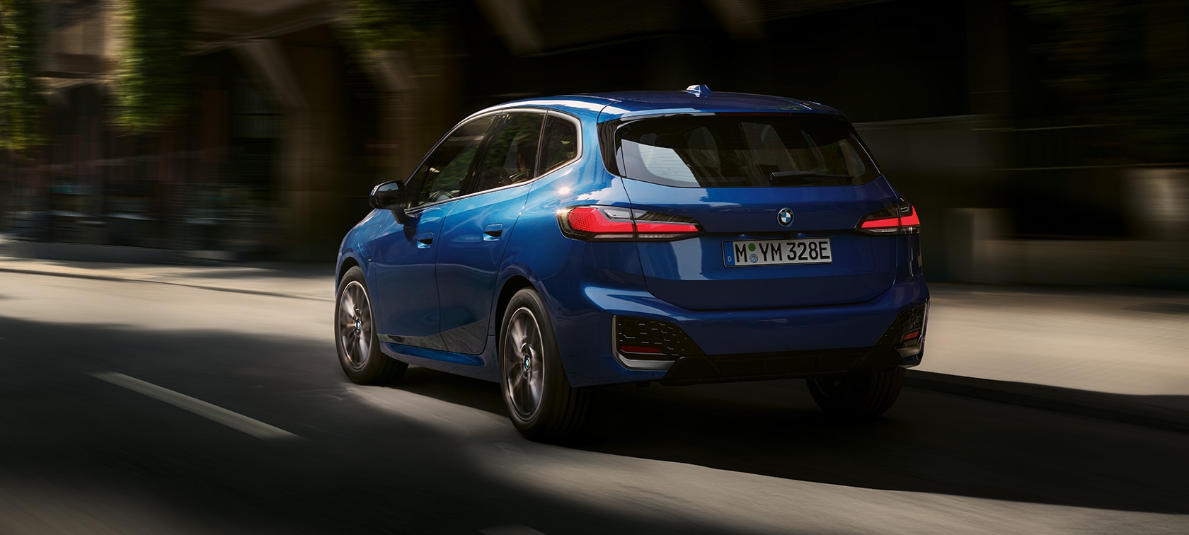 BMW 2-serie Active Tourer 230e plug-in-hybrid U06 2021 M Portimao Blue metallic set bagfra let drejet k&oslash;rende i en by