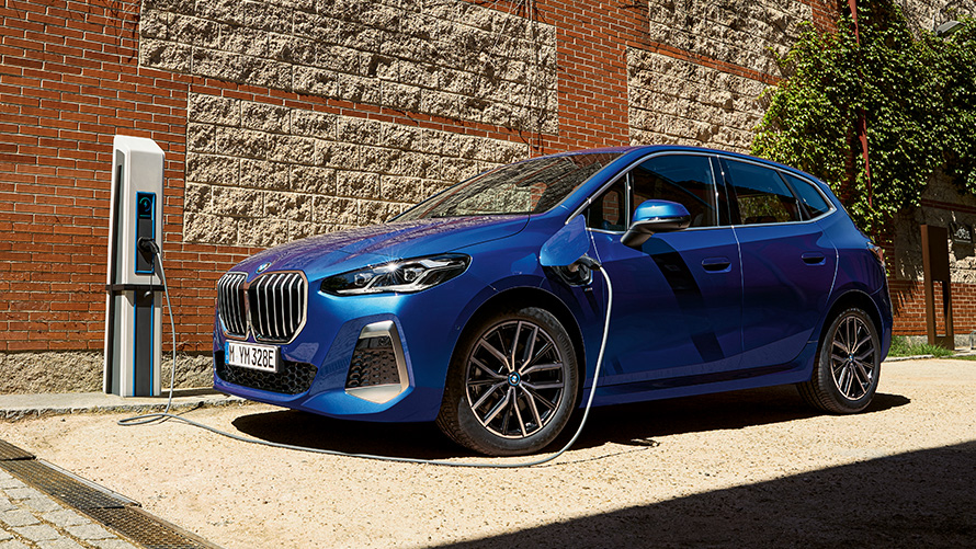BMW 2-serie Active Tourer plug-in-hybrid U06 2021 ved en ladesøjle BMW 2-serie Active Tourer 230e plug-in-hybrid U06 2021 M Portimao Blue metallic set fra siden let drejet ved en ladesøjle