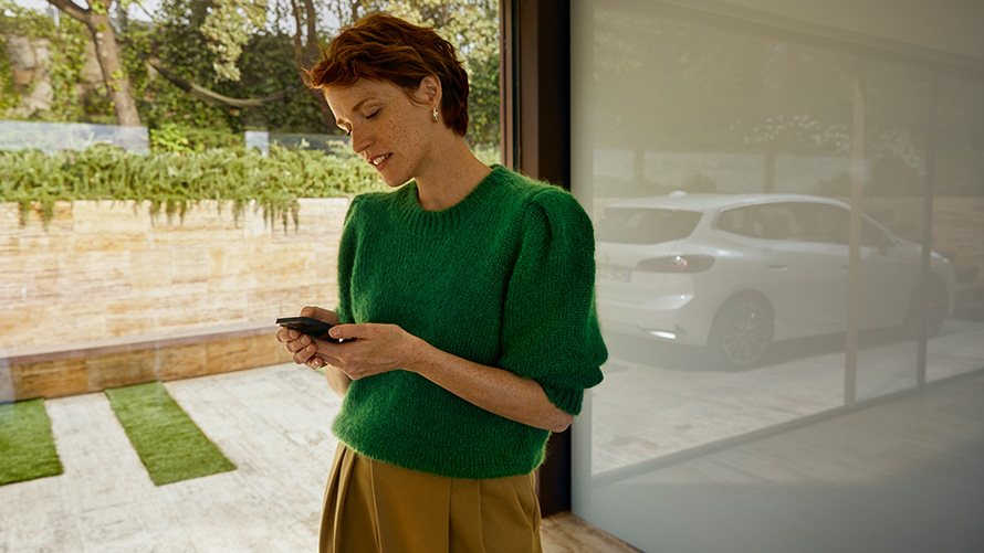 BMW Service Inclusive en kvinde med en smartphone i hånden En kvinde med en smartphone i hånden BMW Service Inclusive