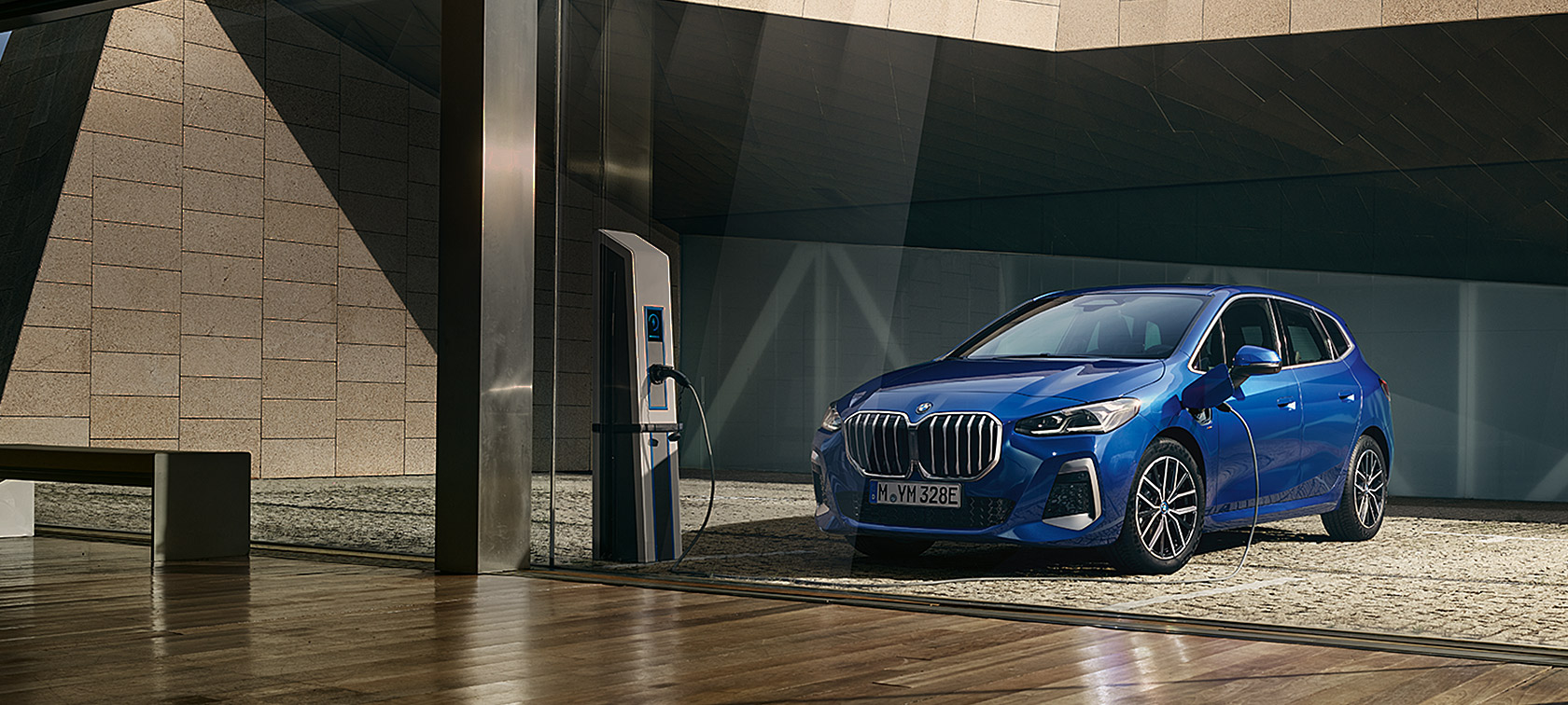 BMW 2-serie Active Tourer 230e plug-in-hybrid U06 2021 M Portimao Blue metallic set forfra let drejet ved en lades&oslash;jle