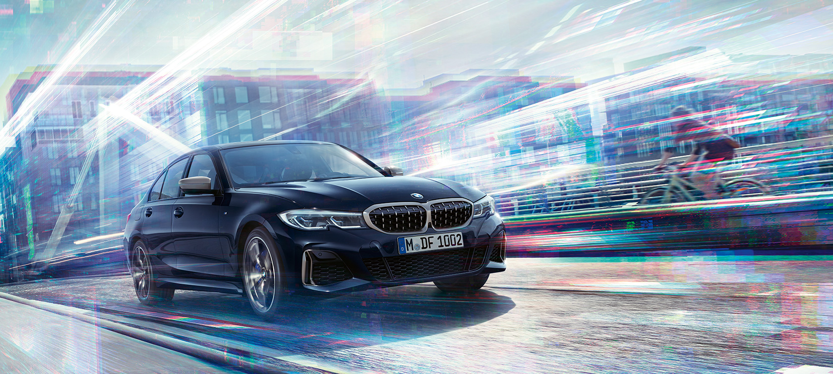 BMW 3-serie Sedan, BMW M340i xDrive. BMW M340i xDrive set fra siden let drejet, kørende på gade i urbant miljø.