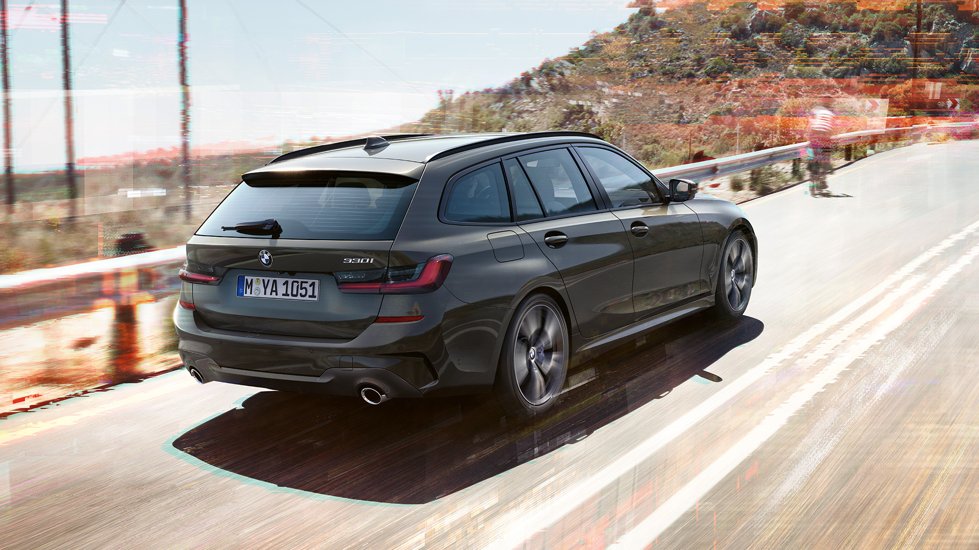 BMW 3-serie Touring set bagfra let drejet BMW 3-serie Touring set bagfra let drejet kørende på en bro foran landlige omgivelser