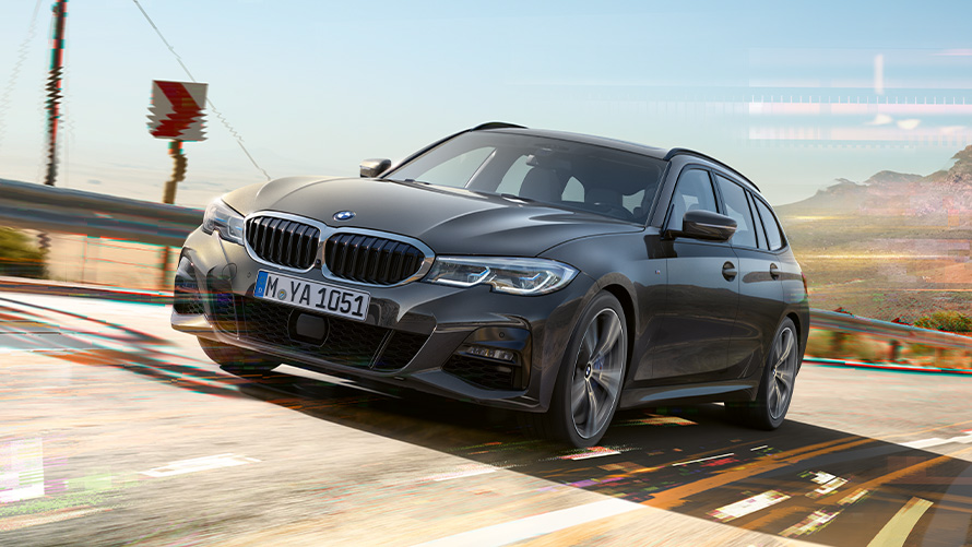 BMW 3-serie Touring (G21) dravitgrå, set forfra let drejet BMW 3-serie Touring (G21) dravitgrå set forfra let drejet kørende i landlige omgivelser