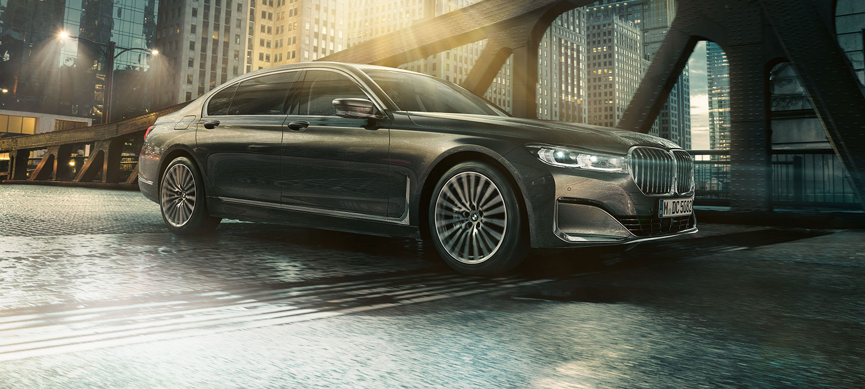 BMW 7-serie Sedan, i profil BMW 7-serie Sedan set fra siden med åben dør foran oplyst hotel