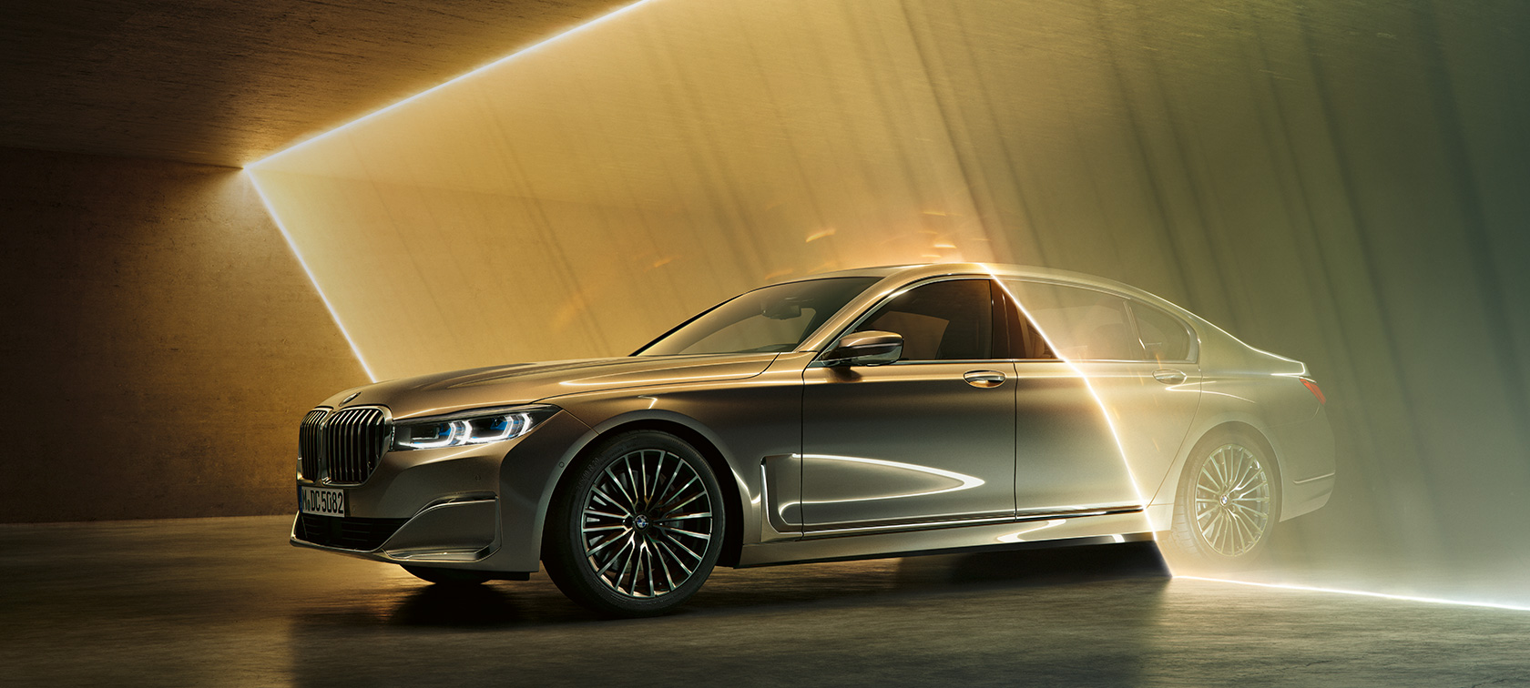 BMW 7-serie Sedan, luksussedan, set forfra let drejet BMW 7-serie Sedan, luksussedan: Grå BMW set forfra let drejet omgivet af lysstråler
