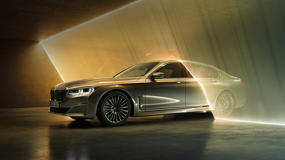 BMW 7-serie Sedan set forfra let drejet BMW 7-serie Sedan: Grå BMW set forfra let drejet omgivet af lysstråler