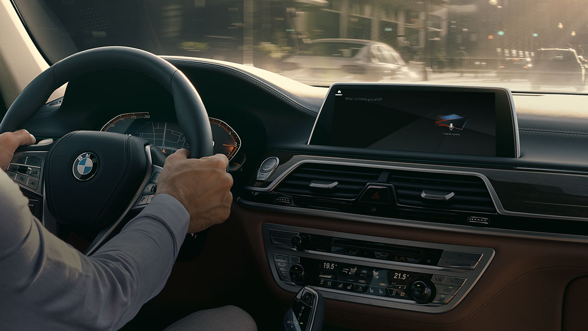 BMW Intelligent Personal Assistant BMW Intelligent Personal Assistant En mand kører i en BMW, nærbillede af Live Cockpit Professional