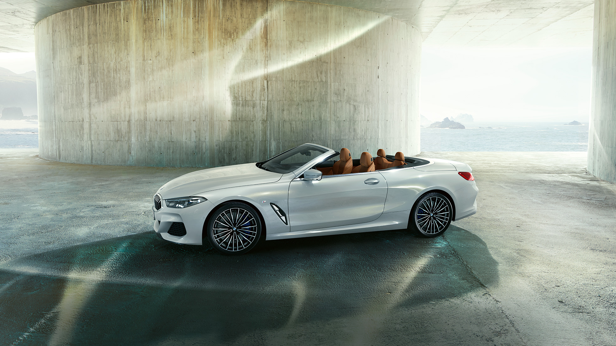 BMW M850i xDrive in Mineral White Metallic, set fra siden med åben stofkaleche. BMW M850i xDrive in Mineral White Metallic, set fra siden med åben stofkaleche.