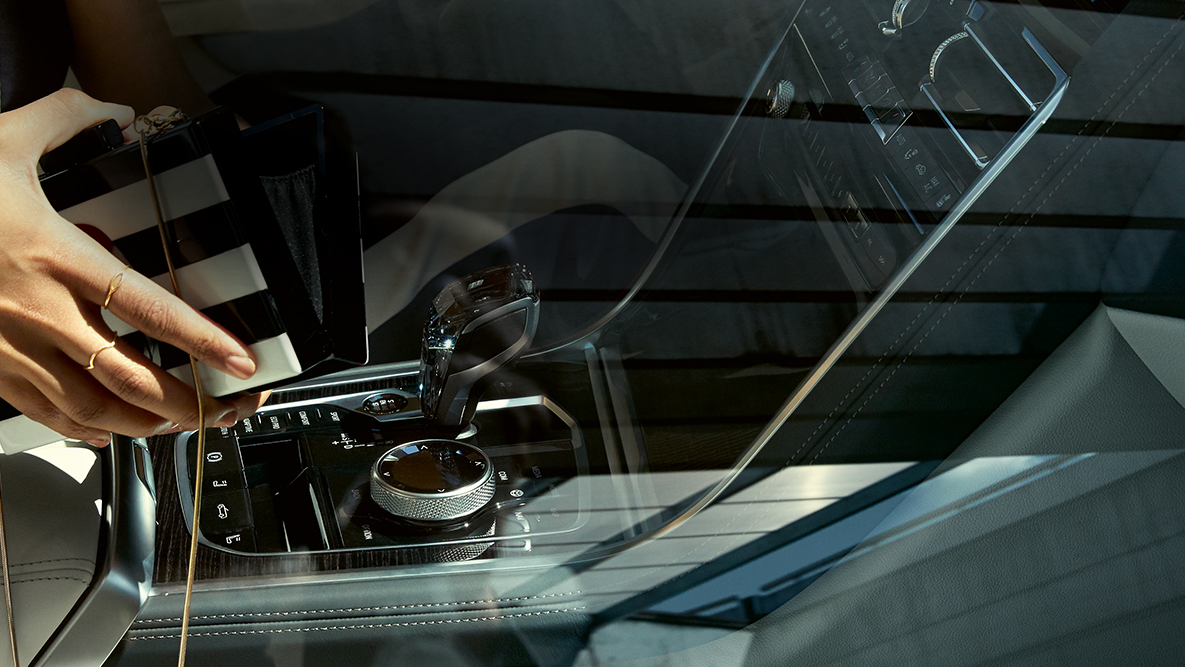 BMW M850i xDrive indvendigt, glasdetaljer "CraftedClarity", kvinde med åben håndtaske. BMW M850i xDrive indvendigt, glasdetaljer "CraftedClarity", kvinde med åben håndtaske.