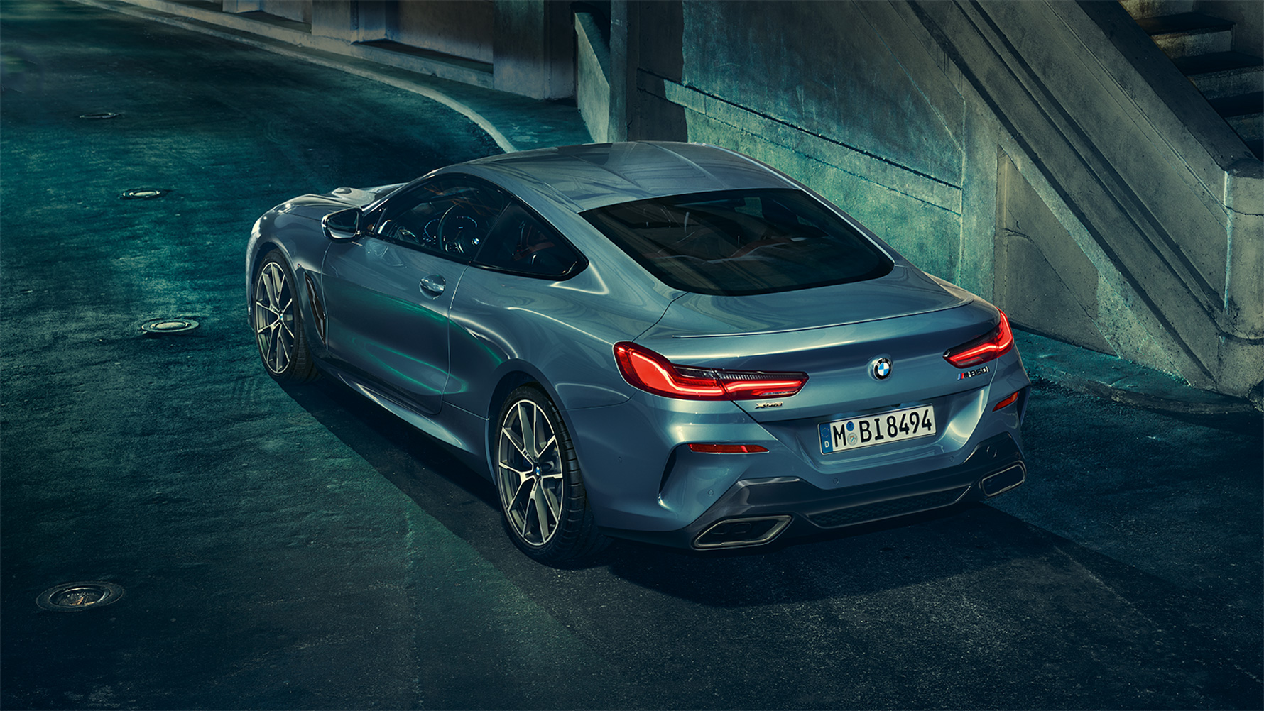 BMW 8-serie Coupé, trekvart bagparti Stillbillede med trekvart bagparti af BMW 8-serie Coupé i et storbymiljø om natten.