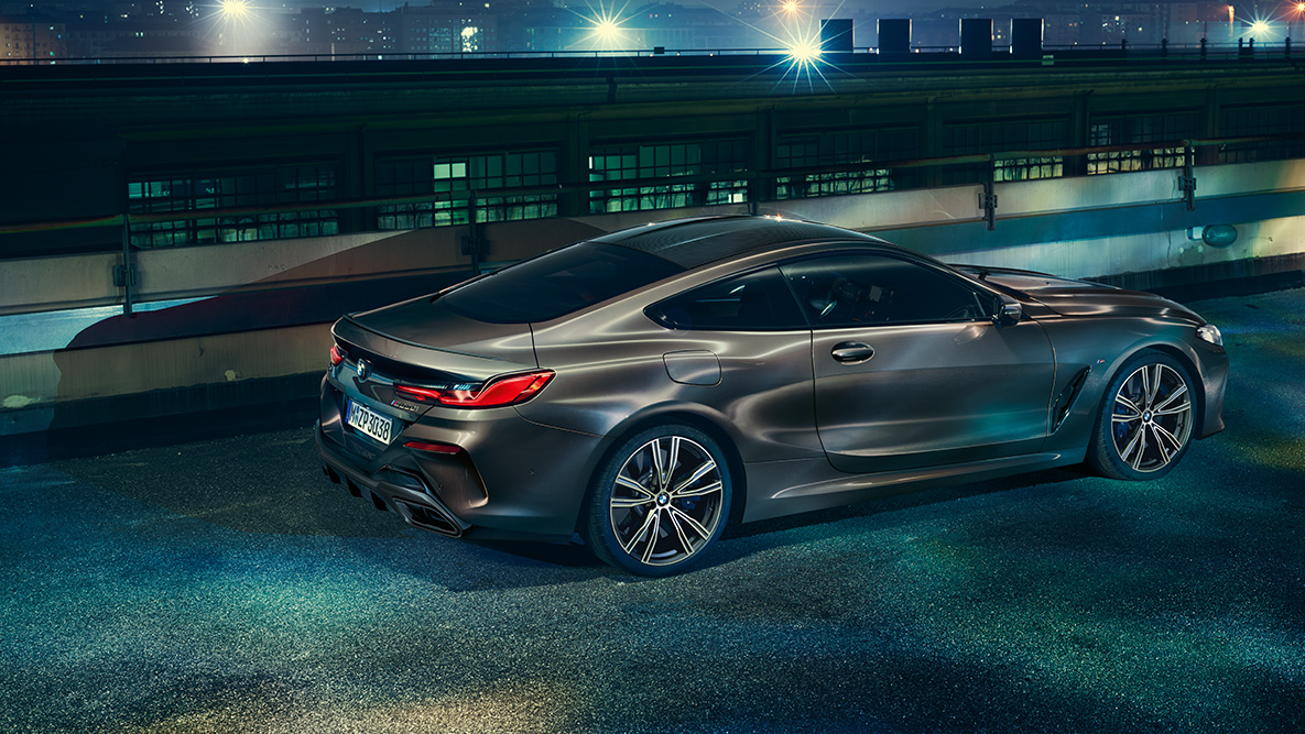 Stillbillede af BMW 8-serie Coupé set fra siden. Stillbillede af BMW 8-serie Coupé med BMW Individual-udstyr fra siden i et natligt storbymiljø.
