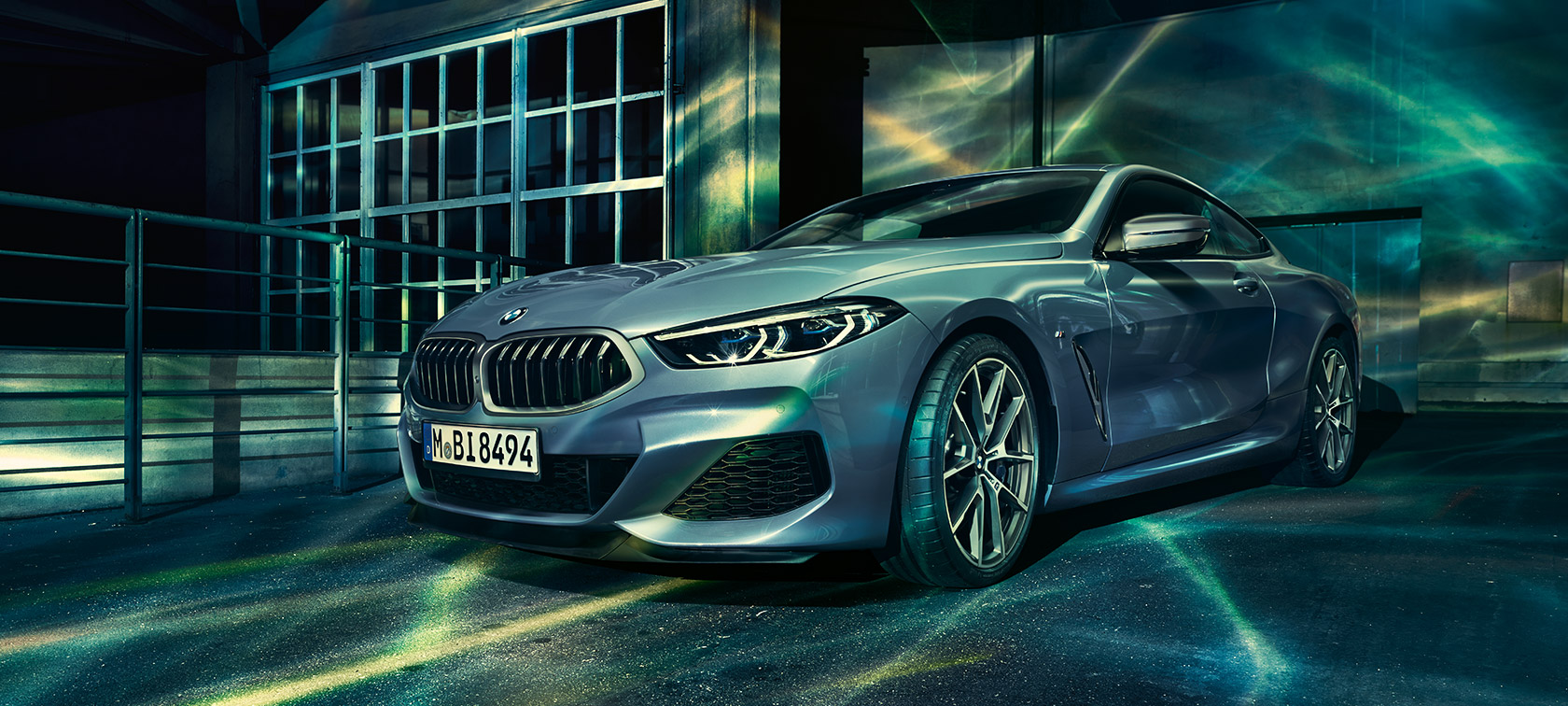 BMW 8-serie Coupé, set forfra let drejet. BMW 8-serie Coupé, set forfra let drejet, foran industribygning.
