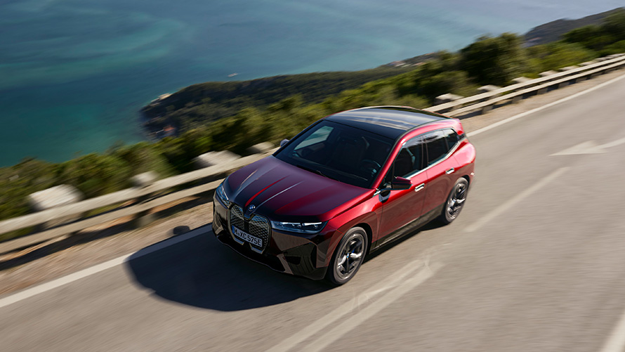 BMW iX i20 elektrisk SUV BMW iX xDrive50 performance BMW iX i20 2021 elektrisk SUV BMW iX xDrive50 Aventurin Red kørende på en vej Performance