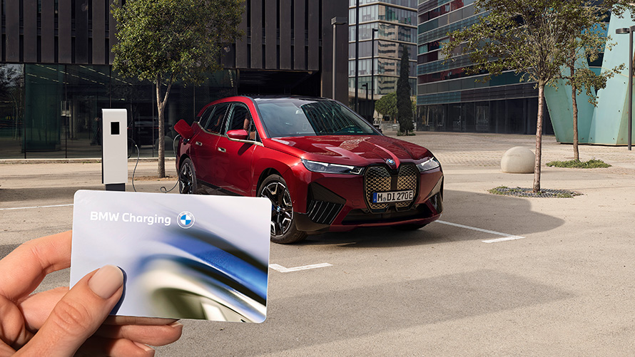 BMW iX i20 elektrisk SUV BMW iX xDrive50 opladning BMW iX i20 2021 elektrisk SUV BMW iX xDrive50 Aventurin Red opladning ved en offentlig hurtigladestation
