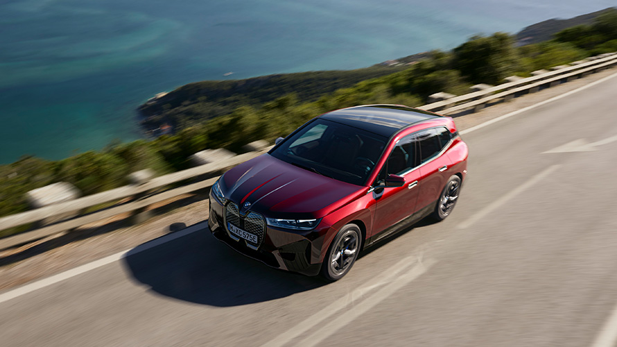 BMW iX i20 elektrisk SUV BMW iX xDrive50 performance BMW iX i20 2021 elektrisk SUV BMW iX xDrive50 Aventurin Red kørende på en vej Performance
