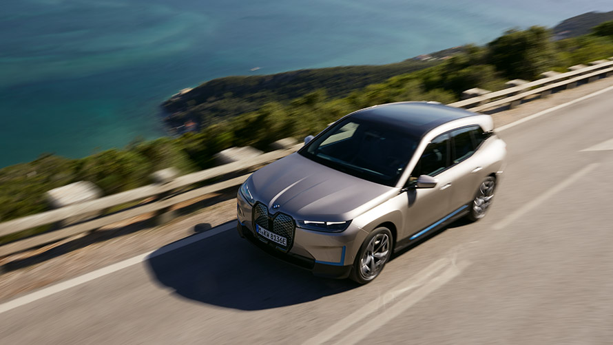 BMW iX set i fugleperspektiv på en vej BMW iX Cashmere Silver i20 set i fugleperspektiv på en vej