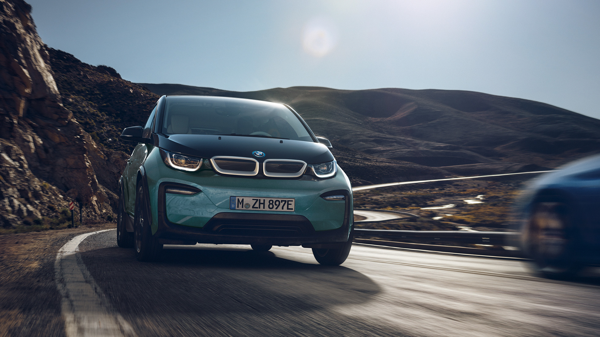 BMW i3 2018 set fra siden kørende BMW i3 I01 2018 Jucaro Beige med detaljer i Frozen Grey metallic set fra siden kørende i urbane omgivelser