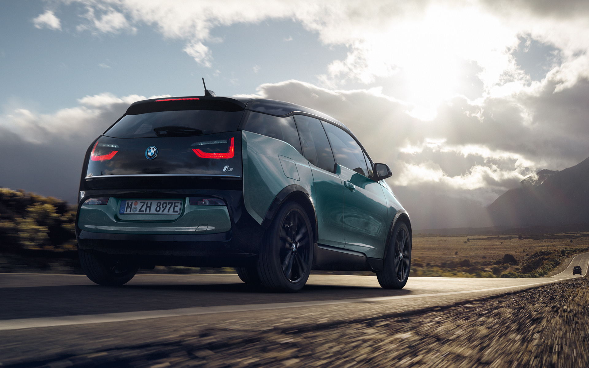 BMW i3 I01 2018 Blue Ridge Mountain med detaljer i Frozen Grey metallic set bagfra let drejet kørende på en landevej