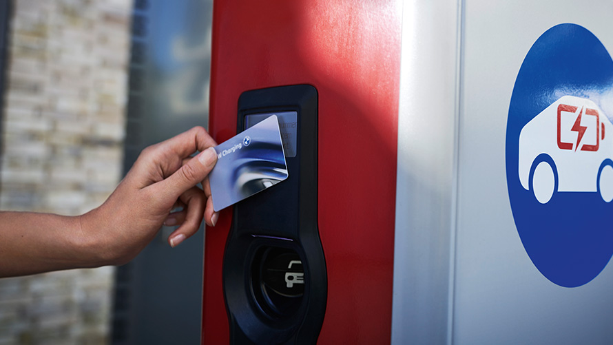En person holder et BMW Charging Card ved en offentlig ladesøjle En person holder et BMW Charging Card ved en offentlig ladesøjle