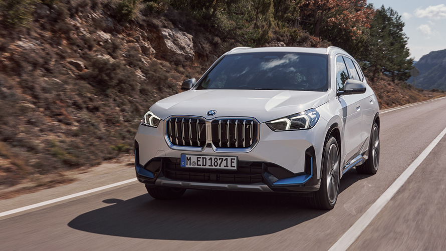 BMW iX1 U11 første generation set forfra let drejet kørende på vejen BMW X BMW iX U11 første generation set forfra let drejet kørende på vejen