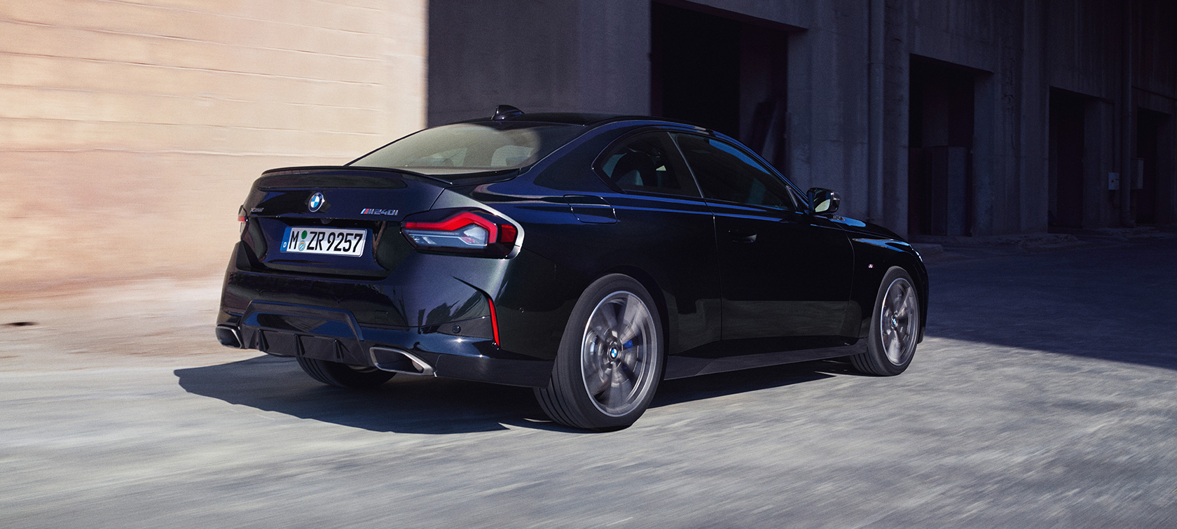 Visning bagfra let drejet BMW M240i xDrive Coupé G42 2021 BMW M240i xDrive Coupé G42 2021 Black Sapphire metallic set bagfra let drejet kørende