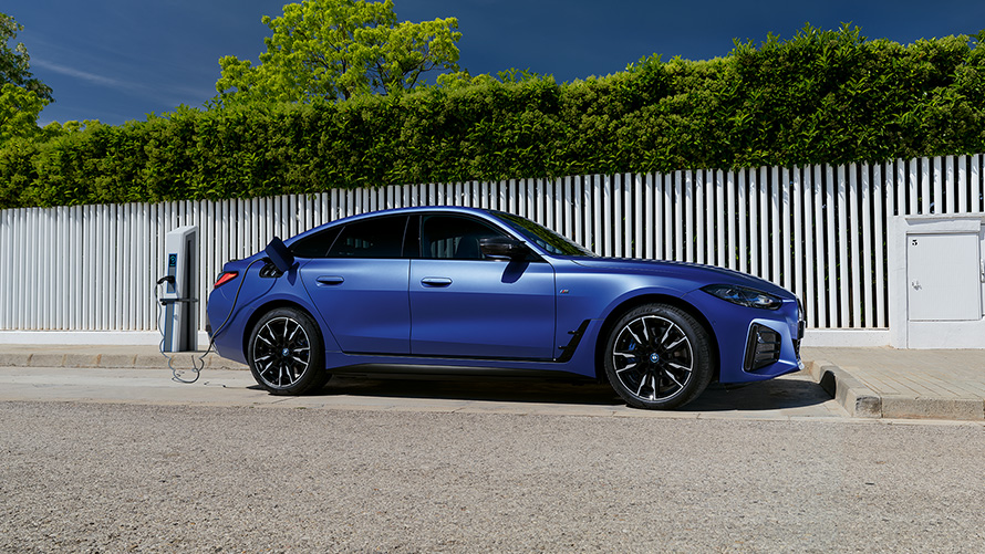 BMW i4 M50 G26 2021 BMW Individual Frozen Portimao Blue metallic set fra siden tilsluttet en ladesøjle