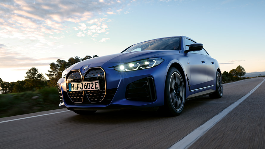 Visning forfra let drejet BMW i4 M50 G26 2021 frøperspektiv BMW i4 M50 G26 2021 BMW Individual Frozen Portimao Blue metallic set forfra let drejet i frøperspektiv kørende