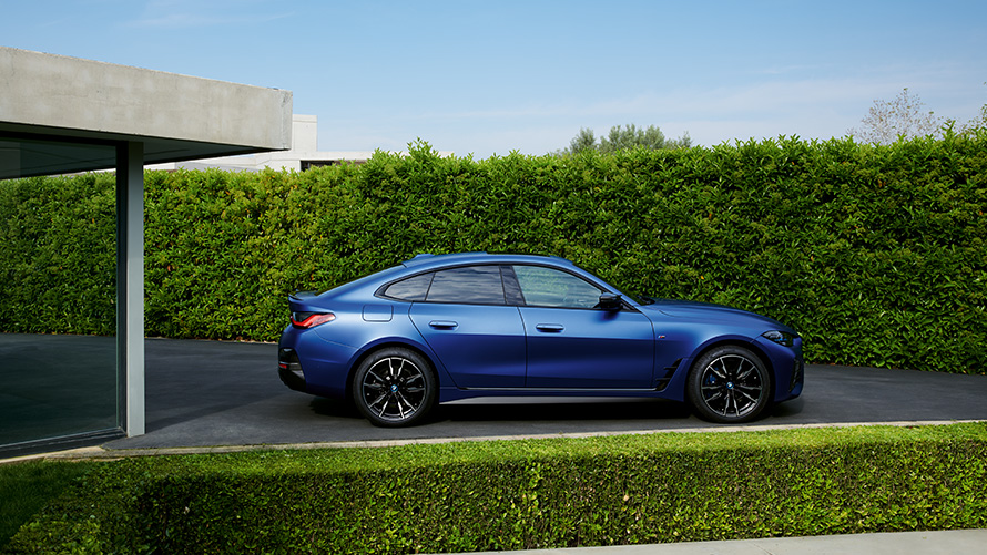 Visning bagfra BMW i4 M50 G26 2021 kørende på en landevej BMW i4 M50 G26 2021 BMW Individual Frozen Portimao Blue metallic set bagfra kørende på en landevej
