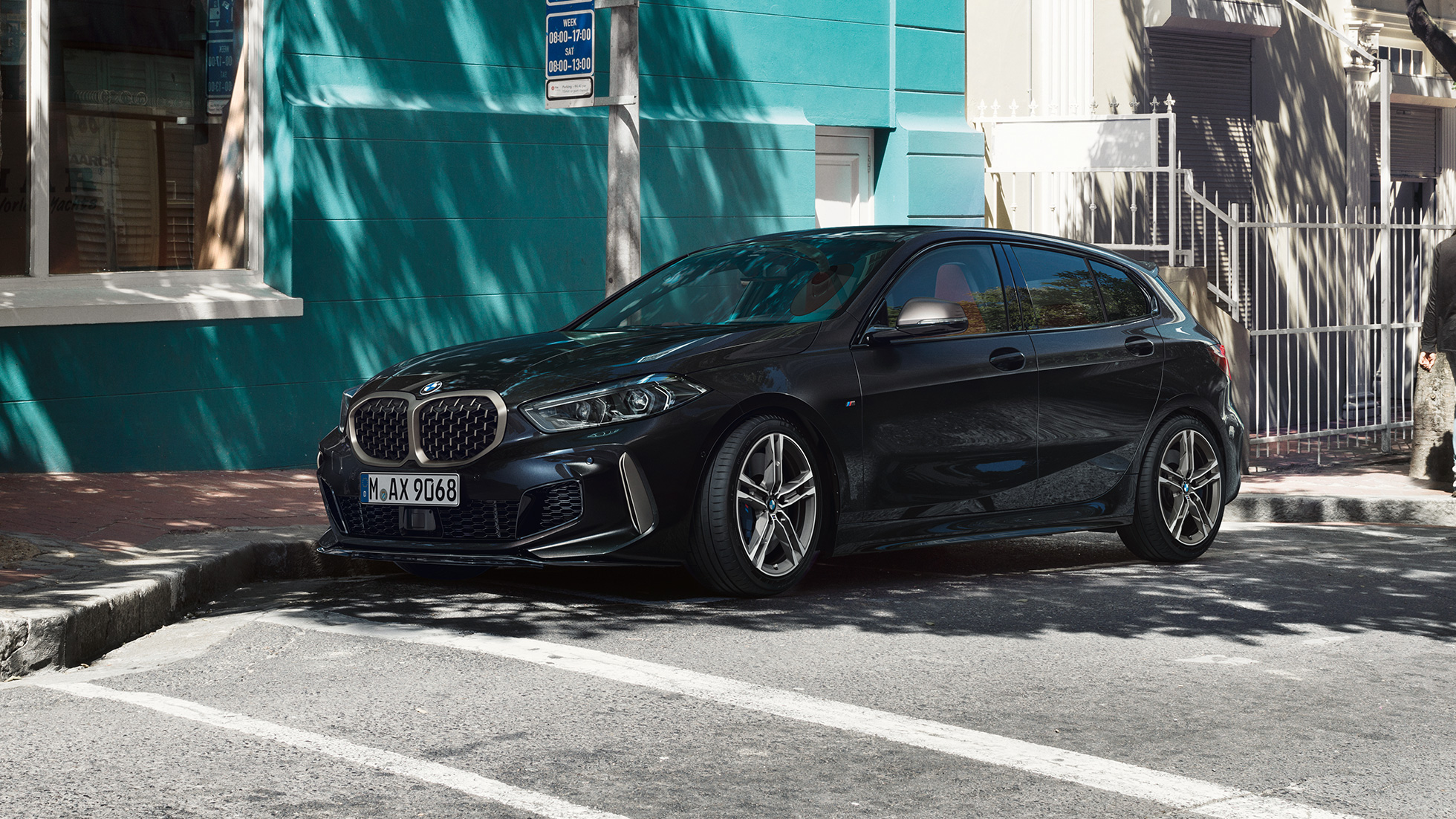 BMW M135i xDrive set fra siden let drejet. BMW M135i xDrive i Sapphire Black metallic set fra siden let drejet, parkerende.
