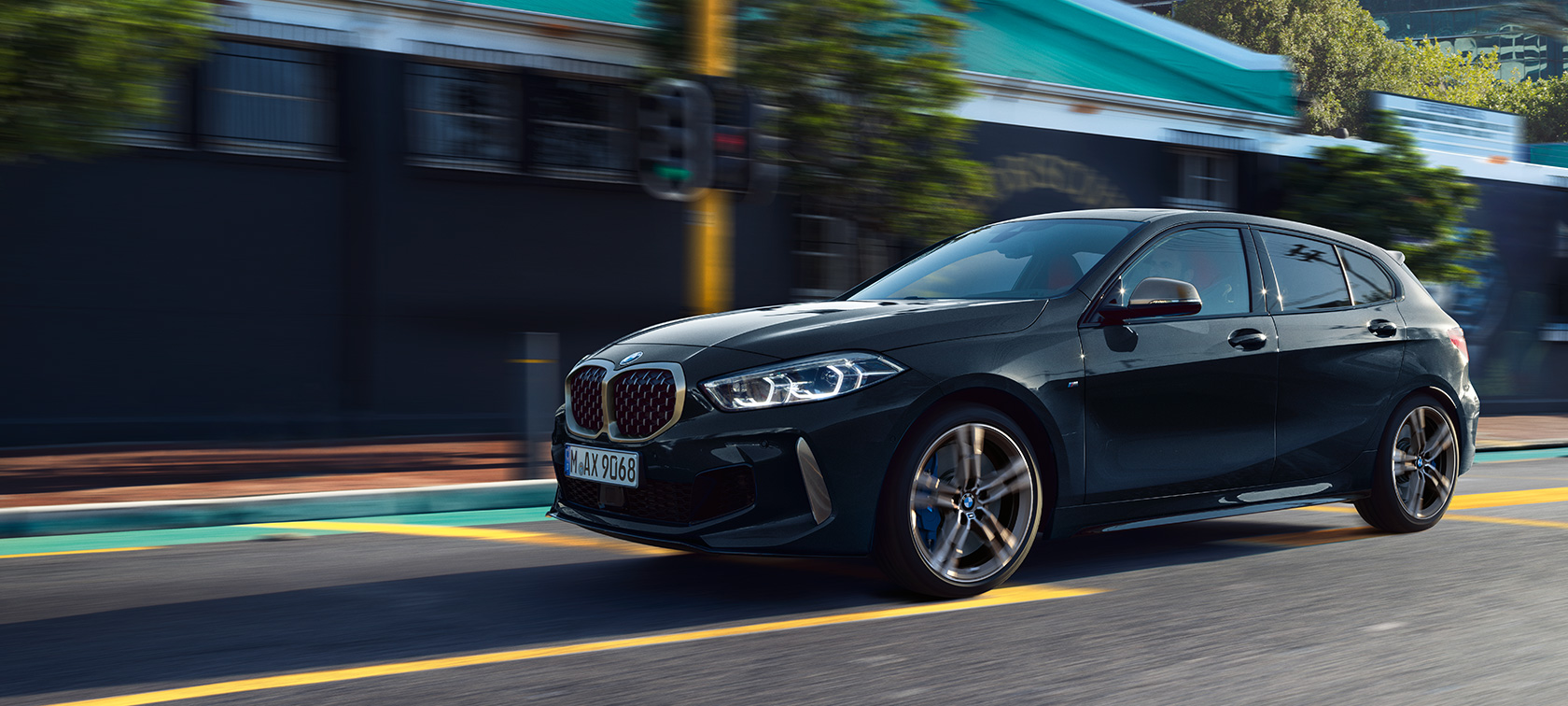 Den nye BMW M135i xDrive. Den nye BMW M135i xDrive i Sapphire Black metallic set fra siden let drejet, kørende.