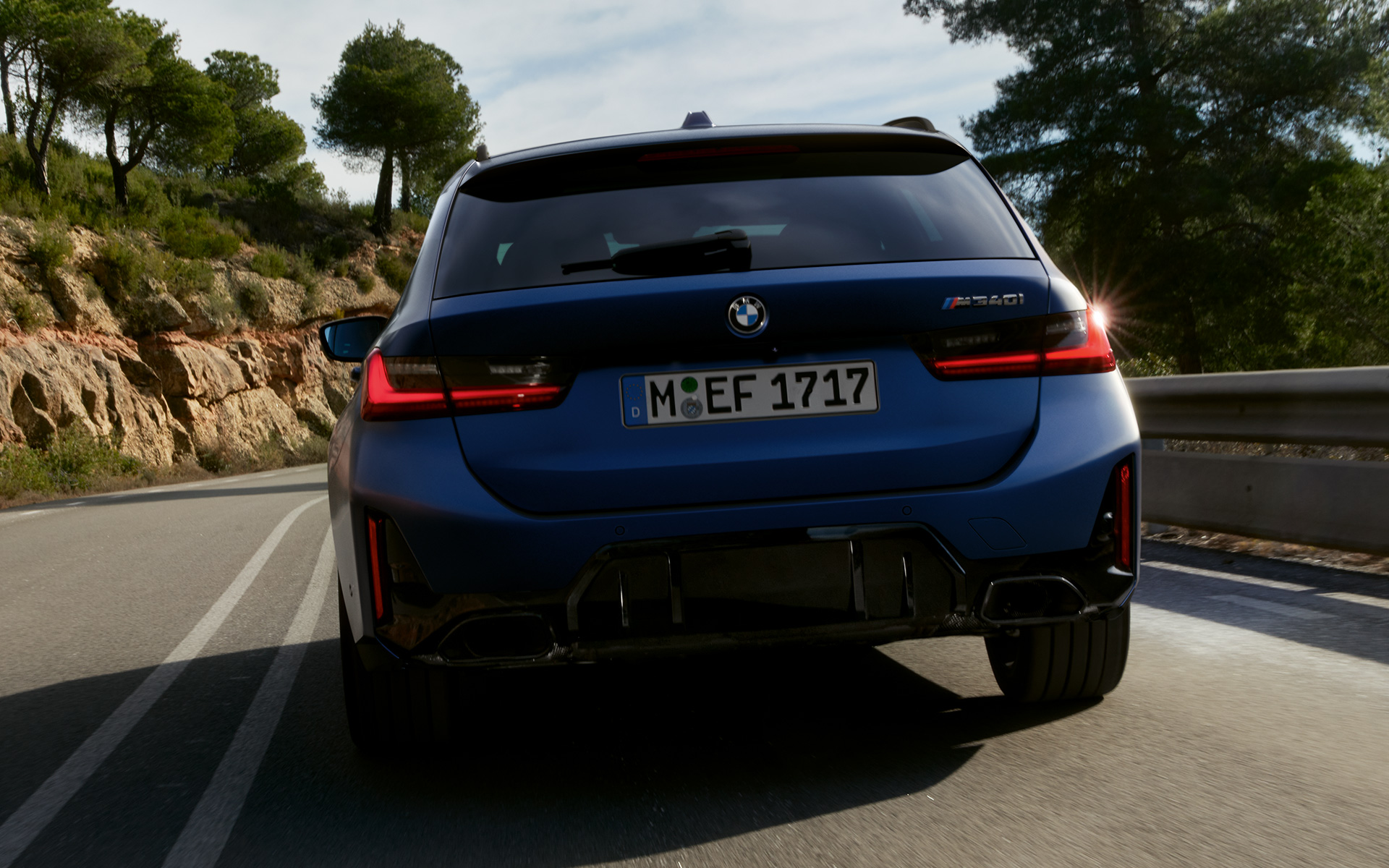BMW M340i xDrive Touring G21, Frozen Tanzanite Blue, set bagfra og kørende på en vej