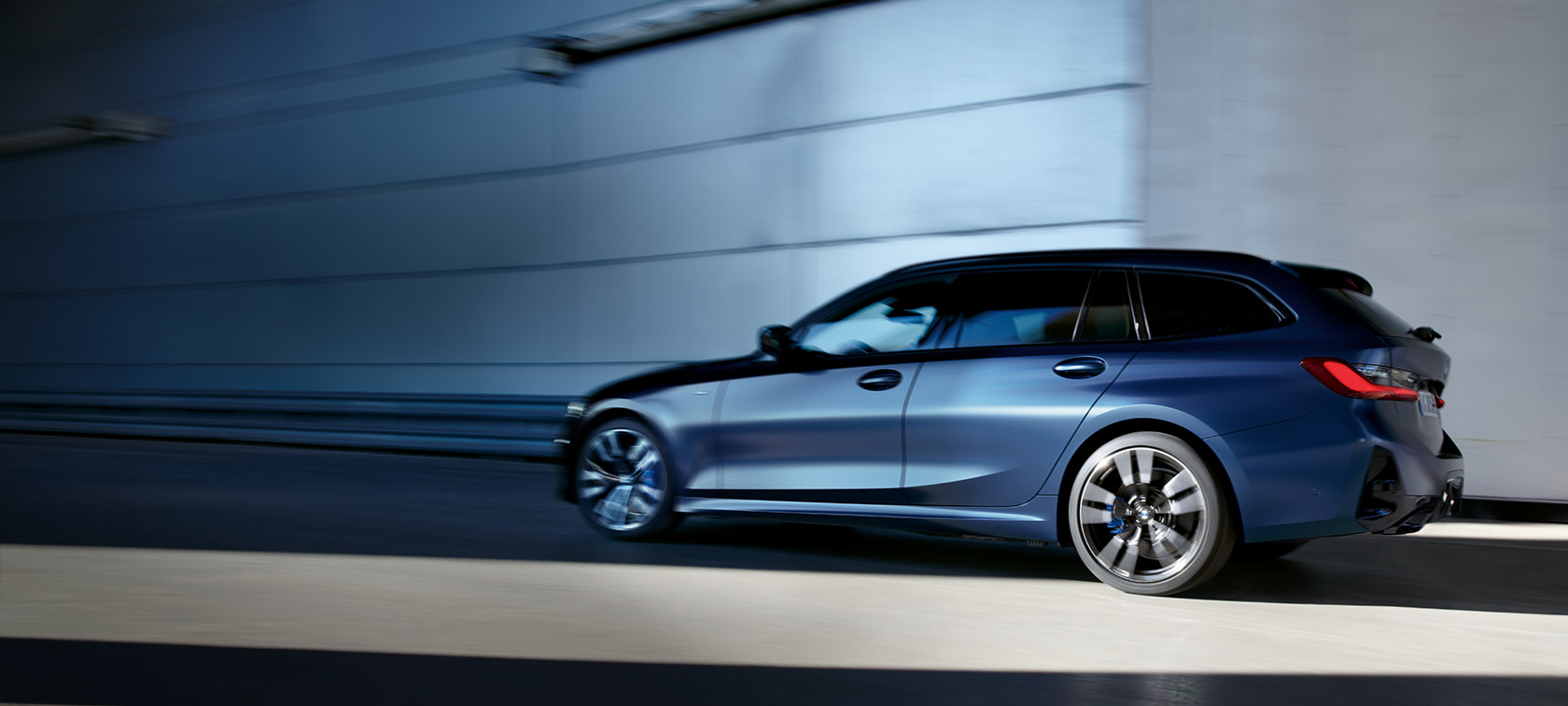 BMW M340i xDrive Touring G21, Frozen Tanzanite Blue, trekvart visning set fra siden og kørende